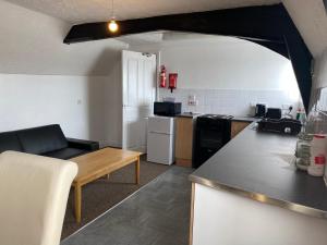uma cozinha com um sofá e uma mesa num quarto em Spacious One Bedroom Flat with River View, 1E em Great Yarmouth