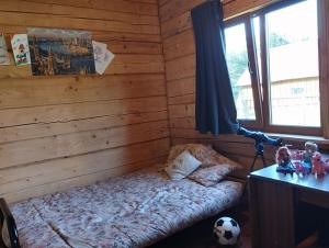 1 dormitorio con 1 cama en una cabaña de madera en Piglet house en Alytus