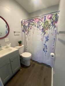 a bathroom with a toilet and a shower curtain at The Cherry Blossom in Sanford