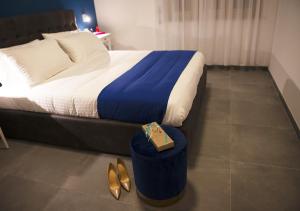 una camera d'albergo con un letto, un tavolo e scarpe di NAPOLI IN BLU MAISON a Napoli