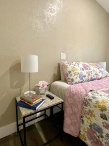 um quarto com uma cama e uma mesa com um candeeiro em The Cherry Blossom em Sanford