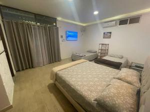 a bedroom with two beds and a couch and a chair at Casa vacacional #2 con vista al mar y piscina con 3 dormitorios , General Villamil Playas-Ecuador in Playas