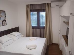 um quarto com uma cama com duas toalhas em Annabell apartman em Tivat