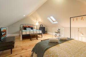 een slaapkamer op zolder met een bed en een televisie bij Modern Design Duplex w/ Balcony in Porto