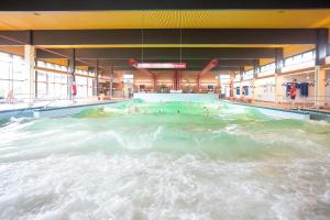 a swimming pool with people in the water at Schoner im Schiffehaus in Wangerland