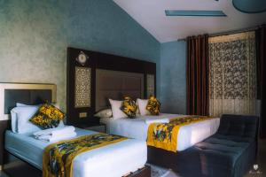 una camera d'albergo con due letti e un divano di Hotel Jibal Chaouen a Chefchaouen