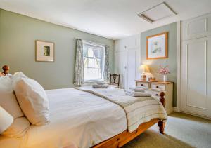 a bedroom with a large bed and a window at Coach House Cottage in Wickham Market