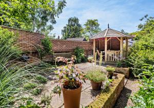a garden with a gazebo and some plants at Coach House Cottage in Wickham Market