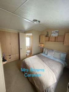 6 Berth, pet friendly caravan with decking في Little Clacton: غرفة نوم بسرير كبير في غرفة