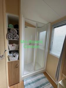 Baño con ducha de cristal y ventana en 6 Berth, pet friendly caravan with decking en Little Clacton