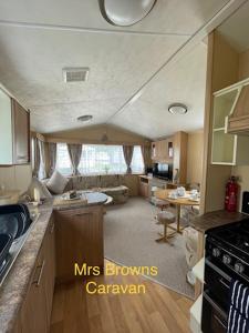 una cocina y sala de estar de una caravana en 6 Berth, pet friendly caravan with decking en Little Clacton