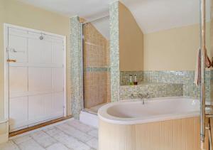a large bathroom with a tub and a shower at Coach House Cottage Sleeps 6 in Wickham Market