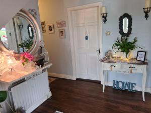 a room with a mirror and a vanity and a door at Coreen Guest House in Tullamore