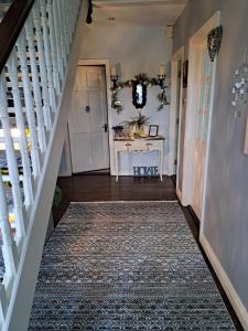 a hallway with a white staircase with a rug at Coreen Guest House in Tullamore