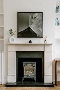 sala de estar con chimenea y TV encima. en Design-led flat in Camden on quiet street, en Londres