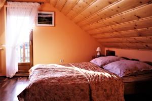 1 dormitorio con cama y techo de madera en Gościniec u Obrochtów, en Zakopane