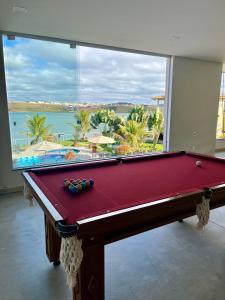 a pool table in front of a large window at Pousada Dona Tereza in Guapé