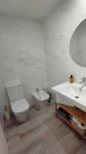 a white bathroom with a toilet and a sink at Habitación con baño privado Bilbao in Bilbao