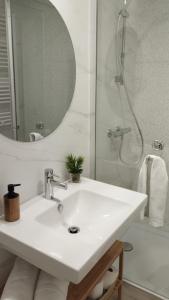 Habitación con baño privado Bilbao في بلباو: حمام أبيض مع حوض ودش