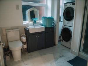 a bathroom with a sink and a washing machine at Seafarer's View - 6 bedroom townhouse in Cowes, parking & seaviews. in Cowes +27 photos