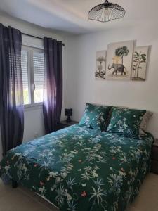 亞維儂的住宿－maison cosy avec petit jardin，一间卧室配有一张带绿色棉被的床