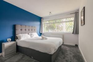 um quarto com uma cama grande e uma parede azul em Comfy Home - Family em Birmingham