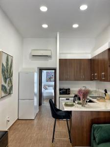 a kitchen with a white refrigerator and a black chair at Charming House in the Heart of Limassol in Limassol
