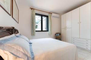 a white bedroom with a bed and a window at vacanze a tremiti in San Domino