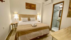 a bedroom with a bed with two towels on it at Pousada Chez Ellery Jeri in Jericoacoara