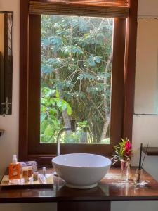 Pousada Bambu Dourado في ماراو: حمام مع حوض كبير أمام النافذة