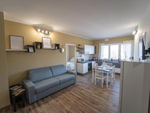 a living room with a blue couch and a kitchen at Central Station Home - Fanale Rentals in Palermo +6 photos