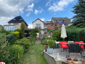 een patio met een tafel en stoelen en een parasol bij Op d'r Vieleberg in Vijlen