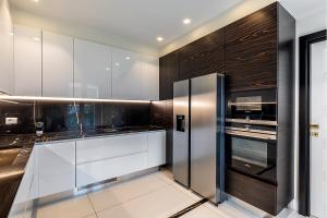a kitchen with white cabinets and a stainless steel refrigerator at Genteel Home Prato in Prato