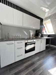a kitchen with white cabinets and a sink at Cozy room with kitchen near the lake in Tõrva