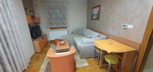 mały salon z kanapą i stołem w obiekcie Apartman Zlatibor Srbija w mieście Zlatibor
