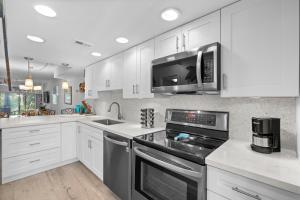 a kitchen with white cabinets and a stove top oven at EXECUTIVE BAY ISLAMORADA BY SOFLA VACATIONS in Islamorada