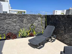 a chair sitting on a patio next to a wall at Casa el Timple in Costa Teguise