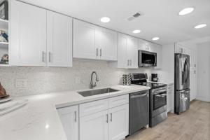 uma cozinha com armários brancos e electrodomésticos de aço inoxidável em EXECUTIVE BAY ISLAMORADA BY SOFLA VACATIONS em Islamorada