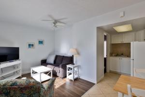 a living room with a couch and a kitchen at Coastal Waters 110 - 1 Bedroom, 1st Floor Pool Side Condo in New Smyrna Beach
