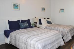 2 camas en un dormitorio con sábanas azules y blancas en Coastal Waters Studio 111 - Pool Side Studio, en New Smyrna Beach