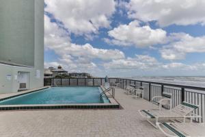 a swimming pool on a balcony next to the ocean at 1 Bedroom -1 Bath With Ocean Views At Ocean Trillium 302 in New Smyrna Beach
