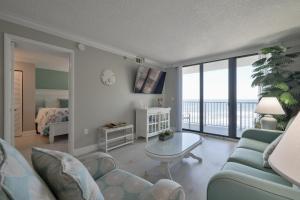 1 dormitorio y sala de estar con sofá y mesa. en 1 Bedroom -1 Bath Ocean View Condo At Ocean Trillium 503, en New Smyrna Beach