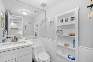 a white bathroom with a toilet and a sink at EXECUTIVE BAY ISLAMORADA BY SOFLA VACATIONS in Islamorada