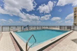 a swimming pool with a view of the ocean at 1 Bedroom -1 Bath Ocean View Condo At Ocean Trillium 802 in New Smyrna Beach