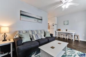 a living room with a couch and a table at Coastal Waters Life - 2nd Floor 1 Bedroom! in New Smyrna Beach