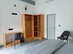 a bedroom with a bed and two chairs and a desk at Fehi Velaa Stay 