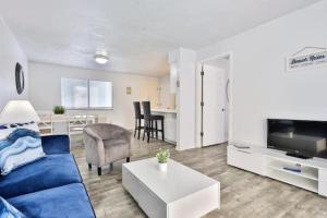 ein Wohnzimmer mit einem blauen Sofa und einem Tisch in der Unterkunft Coastal Waters 210 - 2nd Floor 1 Bedroom With 2 Queen Beds in New Smyrna Beach