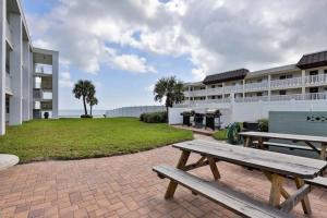 a picnic table on a brick patio in front of a building at Coastal Waters 210 - 2nd Floor 1 Bedroom With 2 Queen Beds in New Smyrna Beach