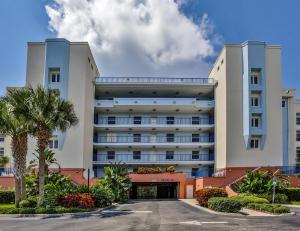 a large white building with palm trees in front of it at 3 Bedroom 2 Bath Oceanwalk Condo With Estuary Views in New Smyrna Beach