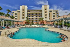 a swimming pool in front of a large building at 3 Bedroom 2 Bath Oceanwalk Condo With Estuary Views in New Smyrna Beach